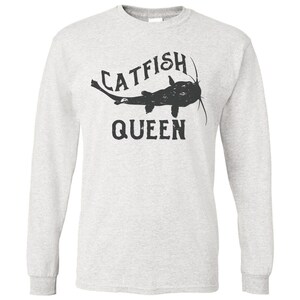 May include: A grey long-sleeved t-shirt with a black silhouette of a catfish and the text "CATFISH QUEEN".