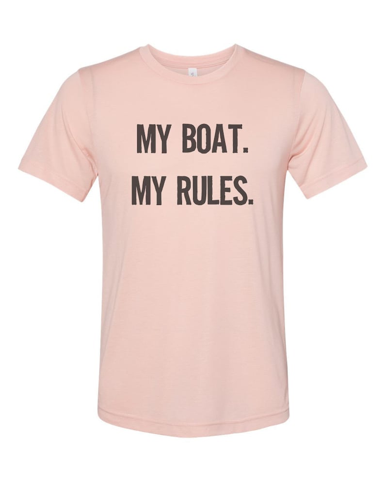 Puede incluir: Una camiseta rosa con el texto "MY BOAT. MY RULES." impreso en negro.
