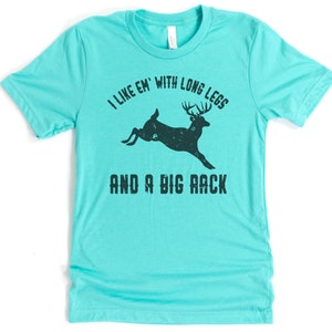 May include: Teal blue t-shirt with a black silhouette of a deer with the text "I like 'em with long legs and a big rack".