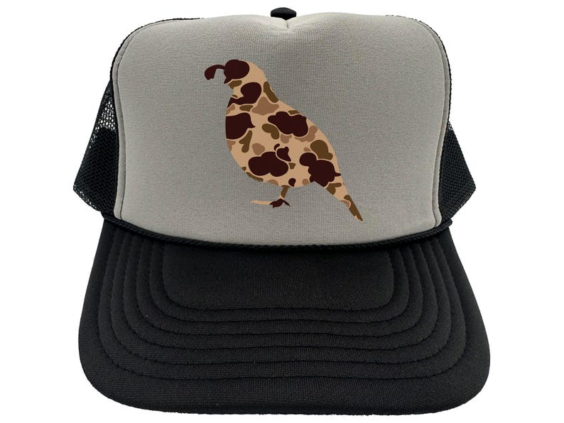 May include: A black and gray trucker hat with a camouflage quail design on the front. The hat has a mesh back.