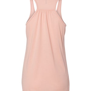 May include: A light pink sleeveless tank top with a gathered detail at the neckline.