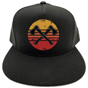 May include: Black trucker hat with a retro sunset design featuring two crossed axes. The hat has a black mesh back.