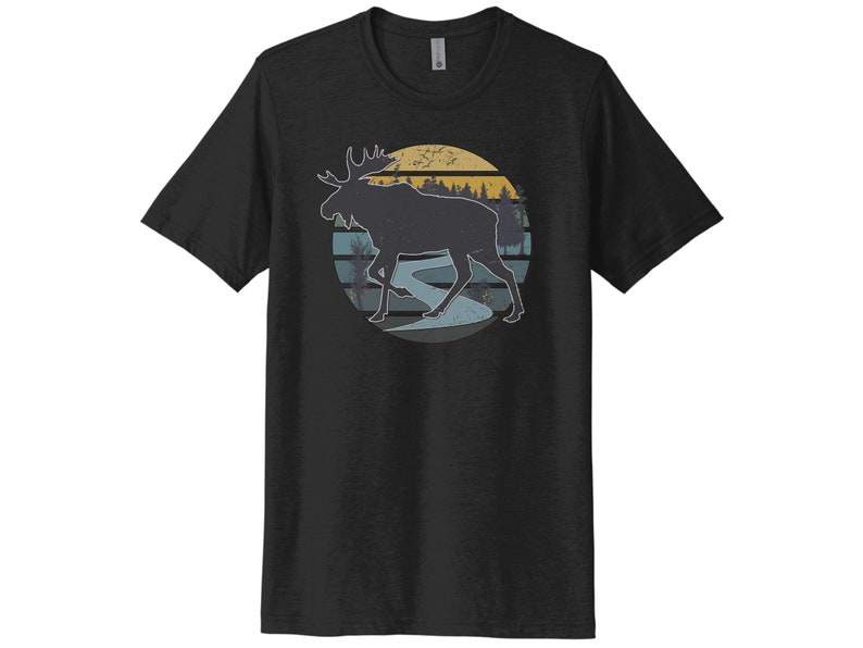 May include: Black t-shirt with a vintage-style graphic of a moose walking through a forest with a sunset in the background.