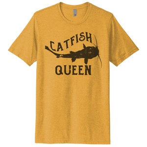 May include: A yellow t-shirt with a black catfish graphic and the text "CATFISH QUEEN".