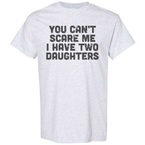 May include: A light grey t-shirt with the text "You can't scare me I have two daughters" printed in black.