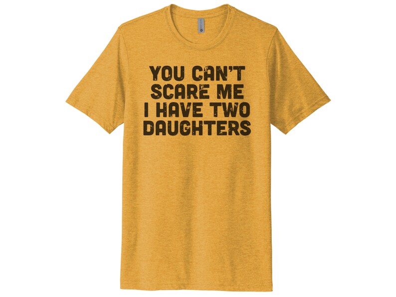 May include: A yellow t-shirt with the text "YOU CAN'T SCARE ME I HAVE TWO DAUGHTERS" printed in black.