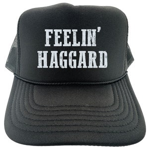 May include: Black trucker hat with a white mesh back. The front of the hat has white text that reads "FEELIN' HAGGARD".