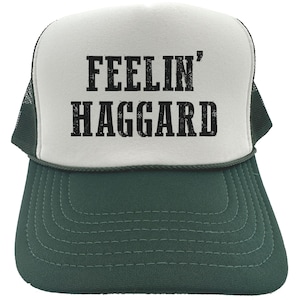 May include: White and green trucker hat with black text that reads "Feelin' Haggard".