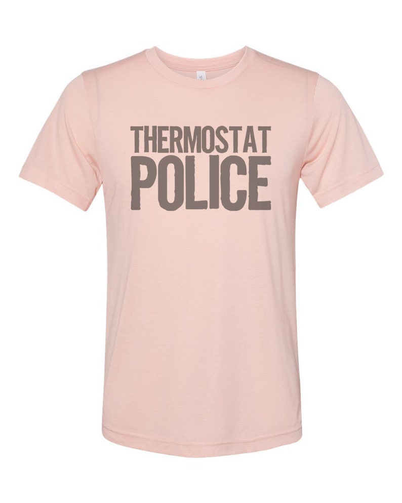 May include: A pink t-shirt with the text "Thermostat Police" printed in brown on the front.