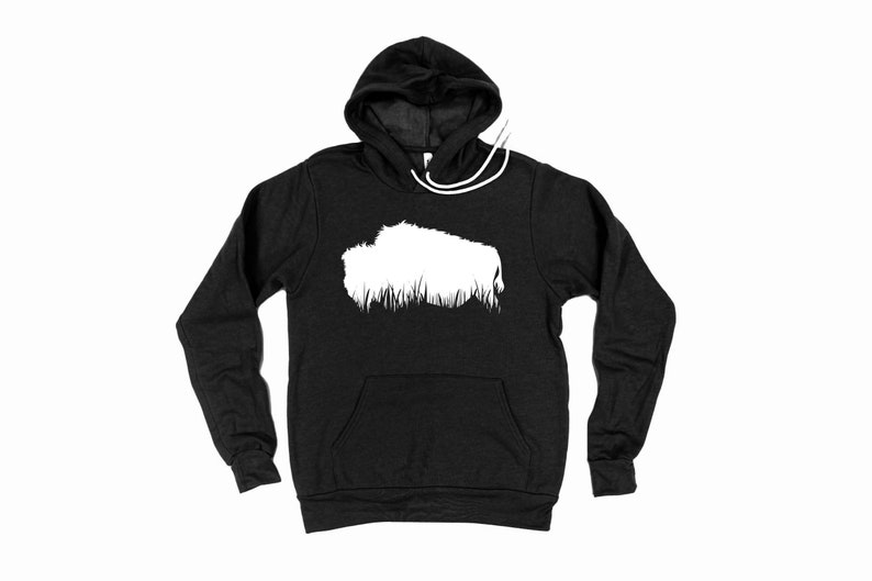 May include: A black hoodie with a white graphic of a bison silhouette above a line of grass. The hoodie has a drawstring hood and a front pocket. The long sleeves are visible.