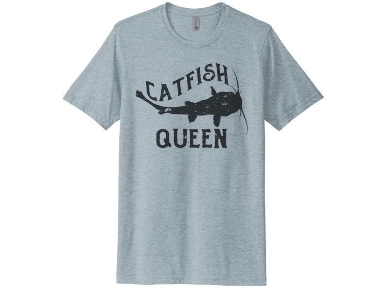 May include: A light blue t-shirt with a black catfish graphic and the text "Catfish Queen".
