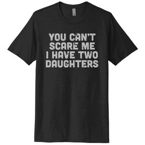 May include: Black t-shirt with white text that reads "You can't scare me I have two daughters".