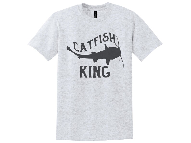 May include: A heather grey t-shirt with a black silhouette of a catfish and the text "CATFISH KING" printed on the front.