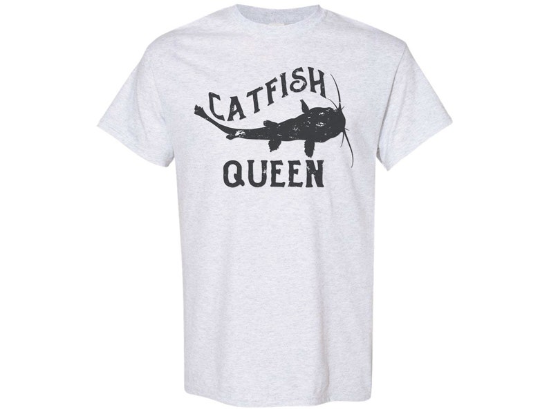 May include: A light grey t-shirt with a black catfish graphic and the text "CATFISH QUEEN".