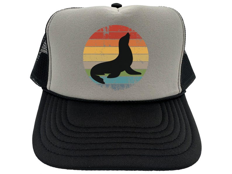 May include: A gray and black trucker hat with a vintage-style graphic of a seal silhouette in front of a rainbow sunset.
