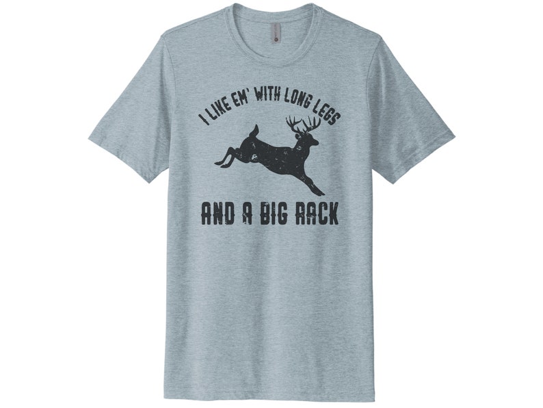 May include: A light blue t-shirt with a black silhouette of a deer with large antlers and the text "I like 'em with long legs and a big rack".