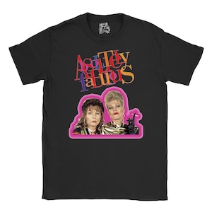 Op de afbeelding: Zwart T-shirt met een roze afbeelding van twee vrouwen. De tekst "Absolutely Fabulous" is in kleurrijke letters boven de afbeelding gedrukt.
