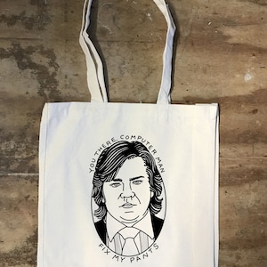 May include: White canvas tote bag with a black and white illustration of a person with the text "You there, Computer Man, Fix My Pants".