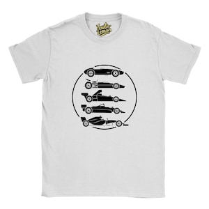 Op de afbeelding: Wit T-shirt met een zwarte afbeelding van vijf klassieke raceauto's in een cirkelvormige opstelling. De silhouetten tonen verschillende auto-ontwerpen uit verschillende raceperiodes. De tee heeft een ronde hals en korte mouwen.