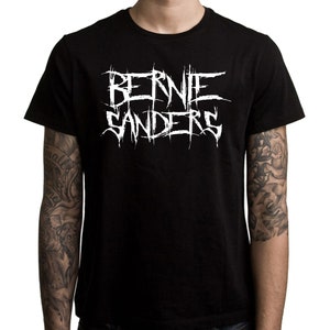 May include: Black t-shirt with a white graphic print of "BERNIE SANDERS" in a stylized, heavy metal font.
