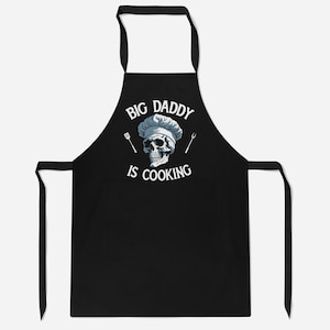 May include: Black apron with a white skull wearing a chef's hat and the text "Big Daddy is Cooking".