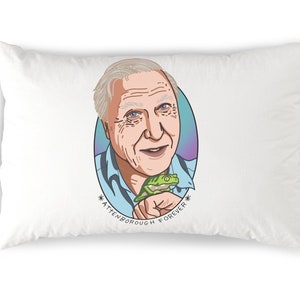 May include: A white pillow with a colorful illustration of Sir David Attenborough holding a green frog. The text *Attenborough Forever* is printed below the image.