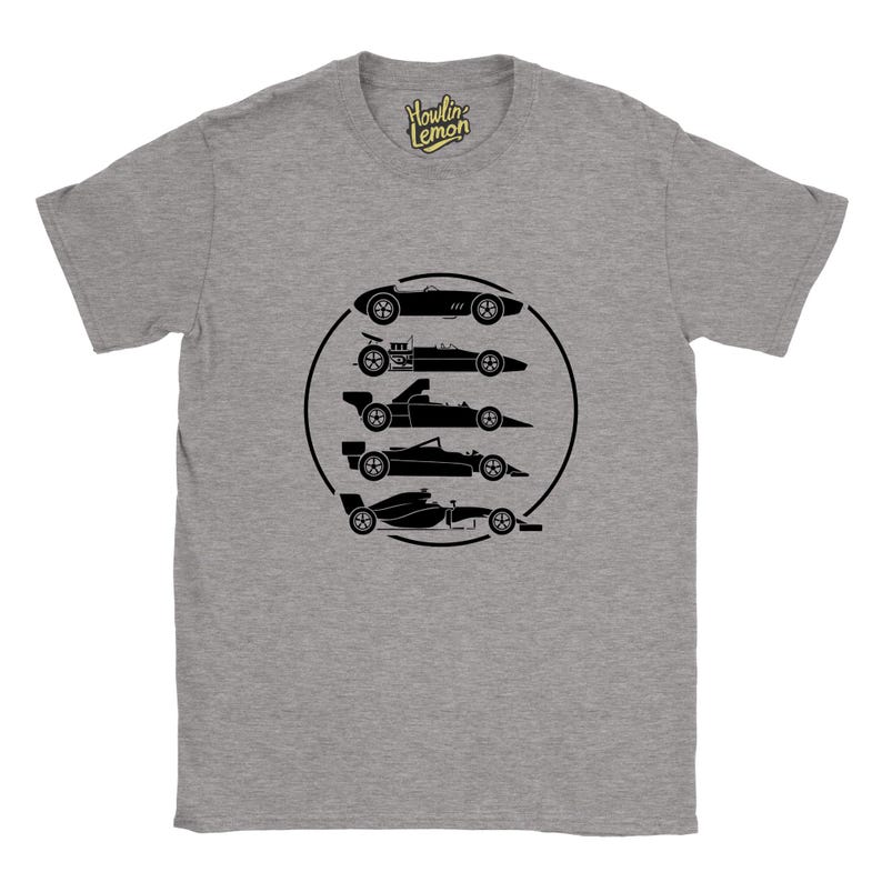 Op de afbeelding: Grijze t-shirt met een zwarte afbeelding van vijf raceauto's in een zwarte cirkel. Het shirt heeft een ronde hals en korte mouwen. De merknaam "Howlin Lemon" staat rechtsboven gedrukt.