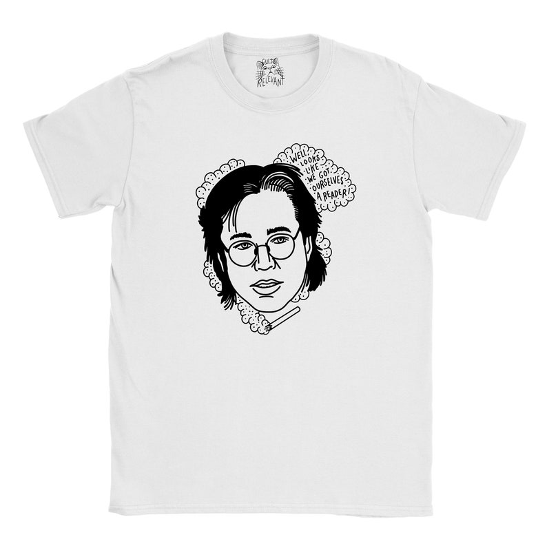 May include: White t-shirt featuring a black and white illustration of a person wearing glasses and holding a cigarette. The text "Well, looks like we got ourselves a reader!" is in a speech bubble above the person's head.