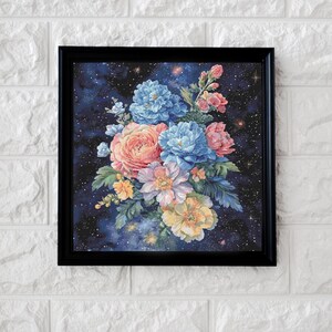 May include: A framed floral print featuring a bouquet of colorful flowers against a starry night sky. The flowers include shades of blue, pink, and yellow, set within a black frame. The artwork is displayed on a white brick wall.
