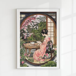 Puede incluir: Impresión enmarcada de una mujer con kimono rosa sentada a una mesa tomando té. La escena está ambientada en un jardín japonés con flores de cerezo y una ventana redonda. La obra es una acuarela.