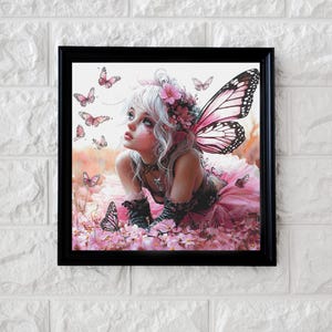 Puede incluir: Una obra de arte enmarcada que presenta una escena de fantasía de un hada con alas de mariposa rosas, rodeada de mariposas y flores. El hada tiene el pelo blanco, una corona floral y viste un vestido rosa. La obra está en un marco negro.