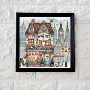 May include: A framed watercolor print of a charming coffee shop with a pink awning, flowers, and string lights. The shop has a sign that says "Coffee Shop". The background features a cityscape with buildings and a clock tower.
