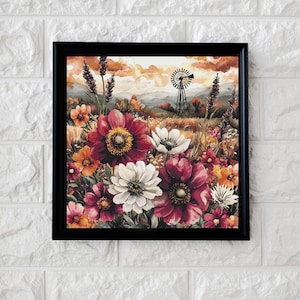 May include: A framed floral print featuring a field of colorful flowers in shades of red, white, orange, and pink. The background includes a windmill, wheat field, and a sunset sky. The artwork is enclosed in a black frame.