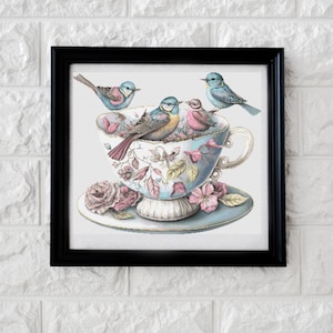 Op de afbeelding: Een vintage theekopje met een bloemenpatroon en vier blauwe vogels die op de rand zitten. Het theekopje staat op een schoteltje met roze rozen.