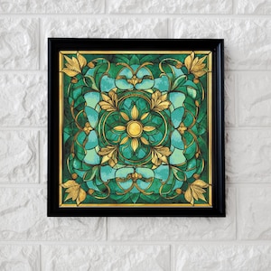 Può includere: Opera d'arte quadrata incorniciata con un design a vetrata. La cornice nera circonda un motivo di elementi floreali dorati e verde-acqua. Il centro presenta un disegno dorato a forma di sole.