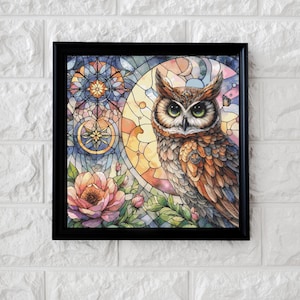 Puede incluir: Obra de arte enmarcada que presenta una ilustración detallada de un búho con ojos verdes, sobre un fondo de estilo vidriera. La obra de arte incluye elementos florales y un diseño celestial, todo dentro de un marco negro. La paleta de colores incluye tonos cálidos de naranja, amarillo y marrón.