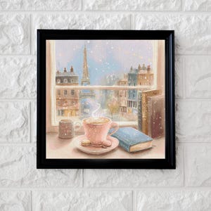 May include: A framed print depicts a cozy Parisian scene. A pink teacup with a saucer and macarons sits near a window overlooking the Eiffel Tower. A small mug and a blue book are also on the table. The artwork is framed in black.