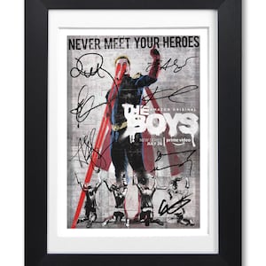 May include: A framed poster for the Amazon Prime Video series "The Boys". The poster features a superhero in a red, white, and blue costume standing in front of a graffiti-covered wall. The text "NEVER MEET YOUR HEROES" is at the top of the poster. The poster is signed by the cast of the show.