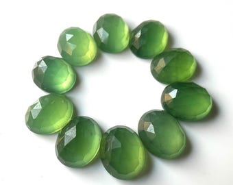 Op de afbeelding: Tien groene, ovale edelstenen met gefacetteerde randen. De stenen zijn in een cirkel op een witte achtergrond gerangschikt.