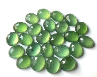 Op de afbeelding: Een verzameling van 20 gefacetteerde ovale groene edelstenen. De stenen zijn doorschijnend en hebben een lichtgroene kleur.
