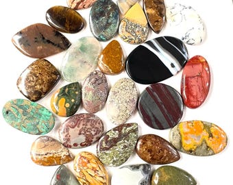 May include: A collection of 25 colorful, natural stone cabochons in various shapes and sizes. The cabochons are polished and have a smooth, glossy finish. They are perfect for jewelry making, crafting, or decorative purposes.