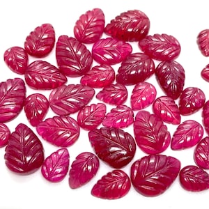 Puede incluir: Una colección de piedras preciosas de rubí en forma de hoja. Las piedras preciosas son de color rojo intenso y tienen un diseño de hoja tallada.