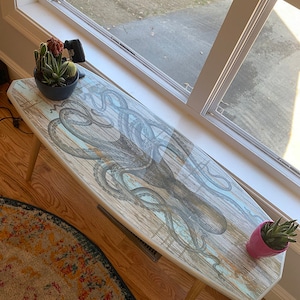 Surfboard coffee table with black octopus print for nautical decor