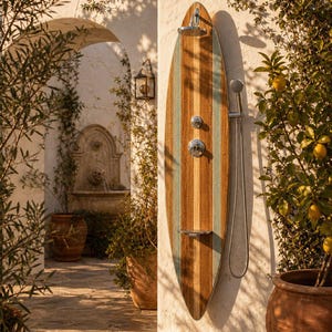 May include: An outdoor shower panel shaped like a surfboard, featuring vertical wood grain stripes in natural brown and light blue. It includes a chrome overhead shower head, a central control valve, a small metal shelf, and a handheld shower sprayer.