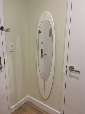 Wall mirror in wooden surfboard shaped frame