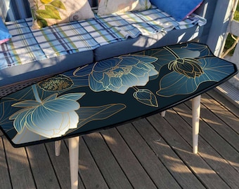 Decorative green surf table with flowers pattern: surfboard shape coffee table with tropical botanical print as living room decor