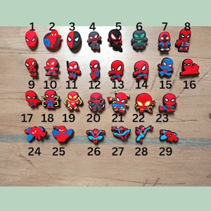 Könnte beinhalten: Eine Sammlung von 29 bunten Spider-Man-Schuhanhängern. Die Anhänger zeigen verschiedene Designs des Superhelden in Rot, Blau und Schwarz. Die Anhänger sind von 1 bis 29 nummeriert.