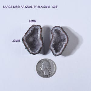 May include: Two AA quality, geode halves, each with a dark interior and a white crystalline border. The geodes measure 26mm x 37mm. A US quarter is included for size comparison. The text "LARGE SIZE: AA QUALITY 26x37MM" is visible.