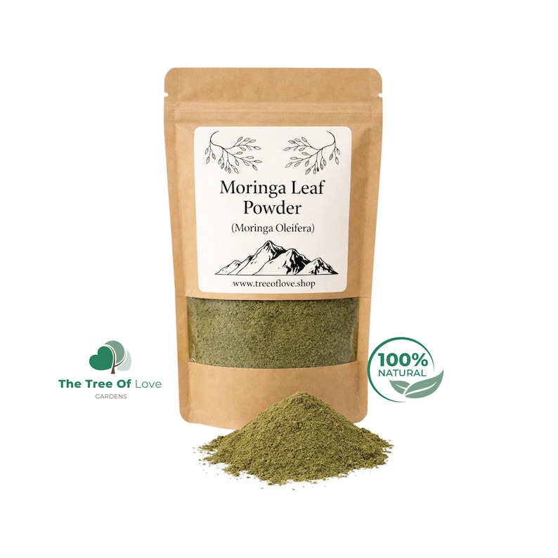 May include: A brown kraft paper pouch containing green Moringa Leaf Powder. The label features the text Moringa Leaf Powder (Moringa Oleifera), a mountain illustration, and the website www.treeoflove.shop. A pile of the green powder sits in front.