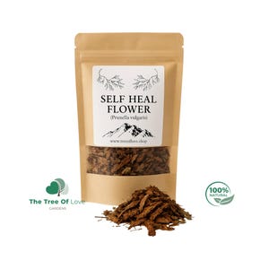 Può includere: Un sacchetto di carta kraft con una finestra trasparente, riempito con fiori di guarigione secchi (Prunella vulgaris). L'etichetta include il testo "SELF HEAL FLOWER" e "100% NATURAL". Un piccolo mucchio di fiori secchi è davanti al sacchetto.